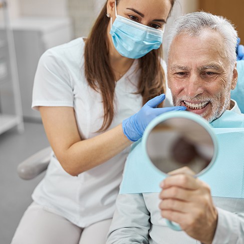 Older man looking at smile in the treatment chair