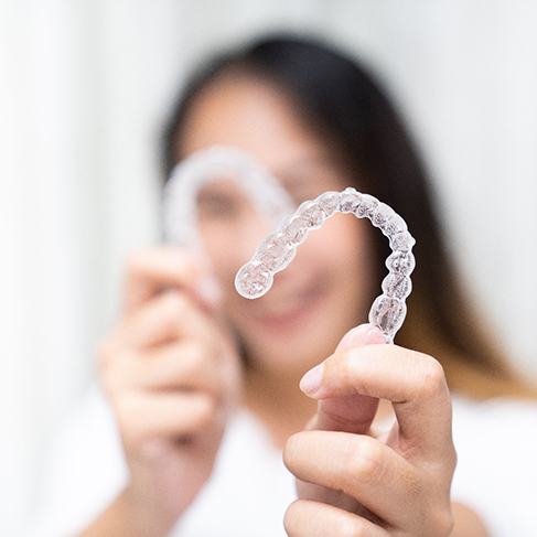 Closeup of patient holding clear aligners